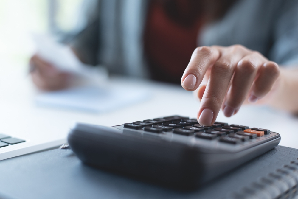  Close up woman's hand using calculator